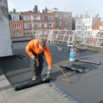 Installation du roofing sur toit plat à l'aide d'un chalumeau