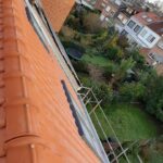 Vue sur des jardins depuis un nouveau toit en tuiles de terre cuite