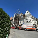 Camionnette et camion Delleuse devant un chantier de rénovation d'un toit