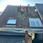 Retrait des tuiles d'une vieille toiture par un couvreur