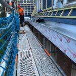 Chantier d'une toiture et d'une corniche en zinc vu de l'échafaudage