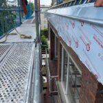 Vue sur l'espace entre un échafaudage et une corniche en cours de rénovation