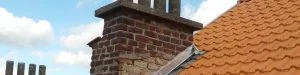Cheminée en brique surplombant une toiture en tuiles